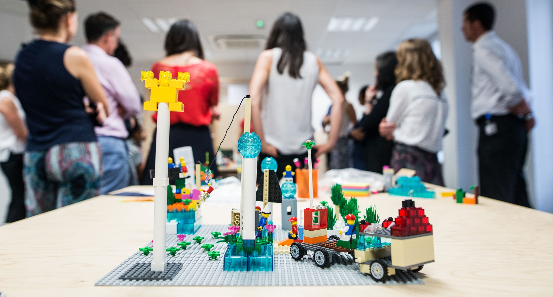 Plateau de lego avec en arrière plan un groupe d’étudiants