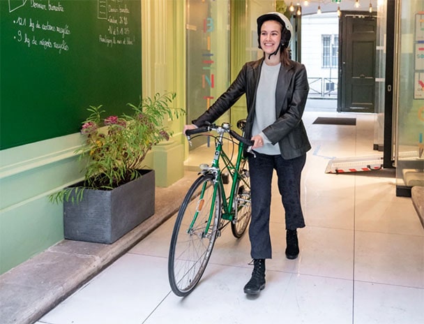 Une femme rentrant dans schoolab avec son vélo