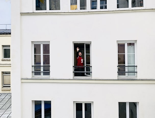 personne saluant a la fenêtre