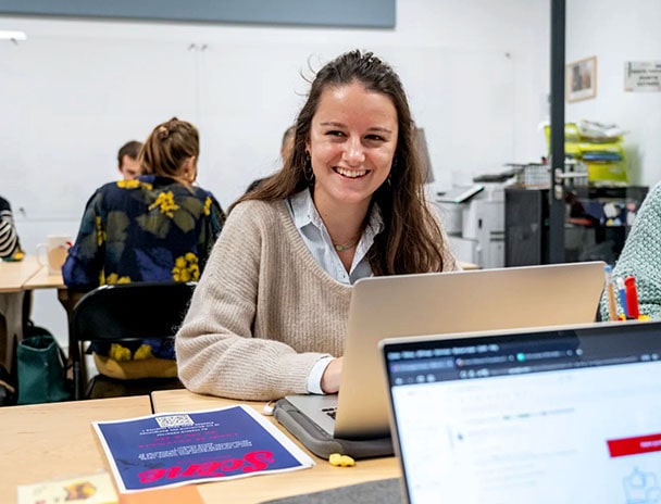 Image d'une femme souriante devant son ordinateur