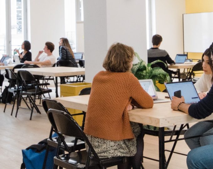 Plusieurs groupes d'entrepreneurs dans une grande salle de Schoolab