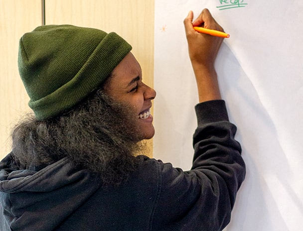 Femme qui sourit devant le tableau