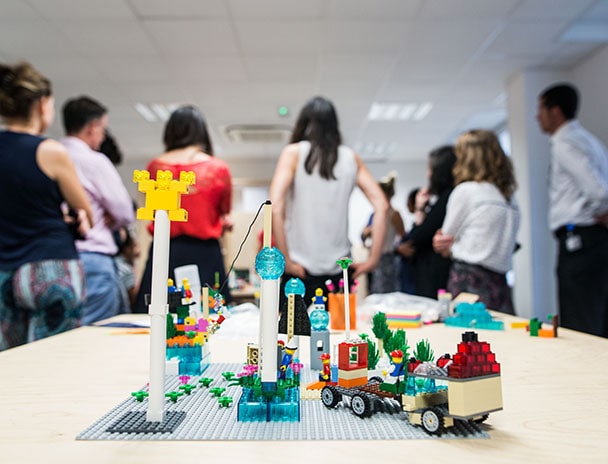 Plateau de lego avec en arrière plan un groupe d’étudiants