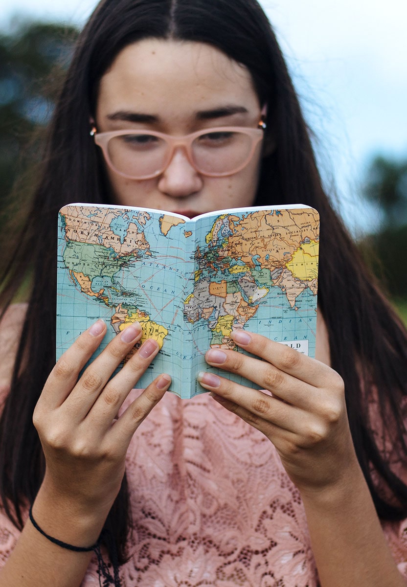 Une fille qui regarde un carnet avec une carte pour le Visa French Tech for founders