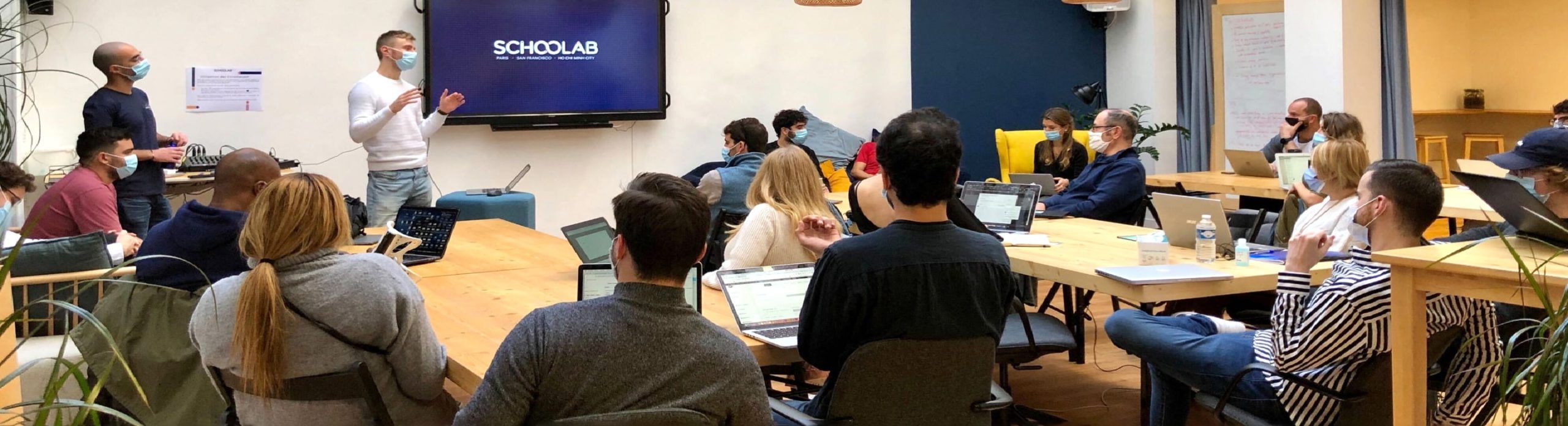 The start-up pris en photo qui écoutent une présentation dans les anciens bureaux de Schoolab