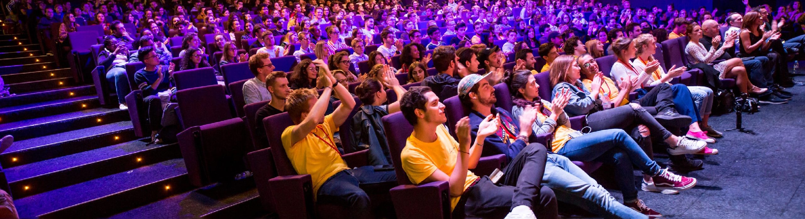 100 et plus d'étudiants applaudissent a la fin d'un hackathon