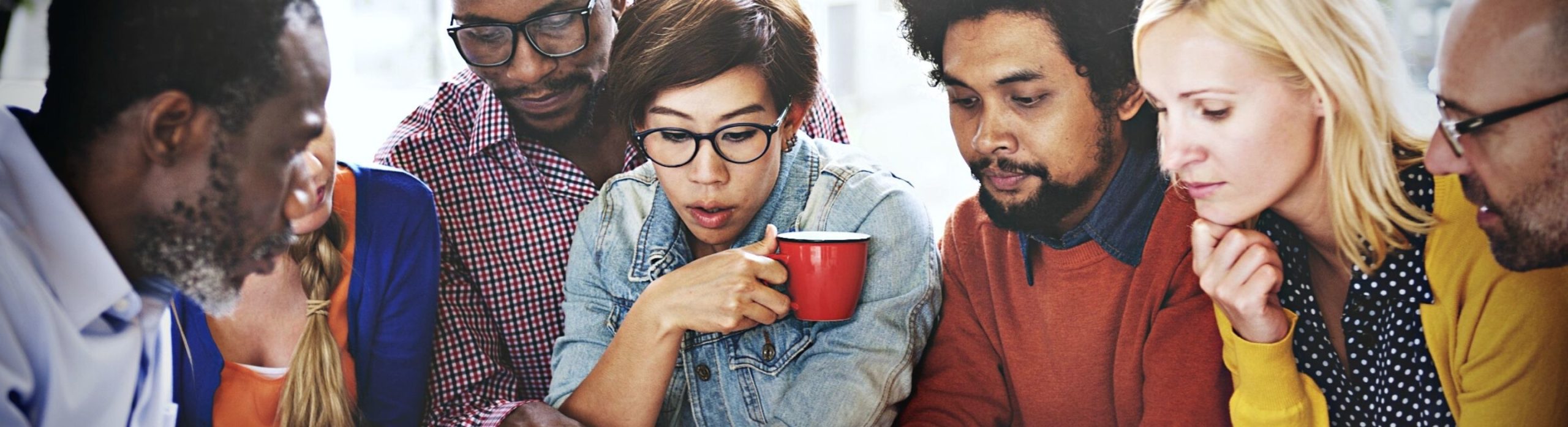 Une groupe de personnes de Schoolab assis en réunion collaborent et échangent des idées ensemble