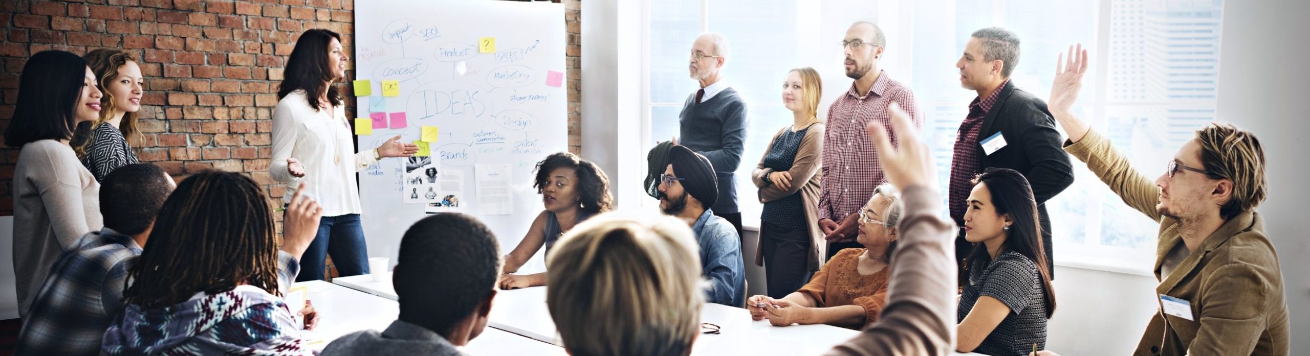 Une groupe de personnes de Schoolab assis en réunion collaborent et échangent des idées ensemble
