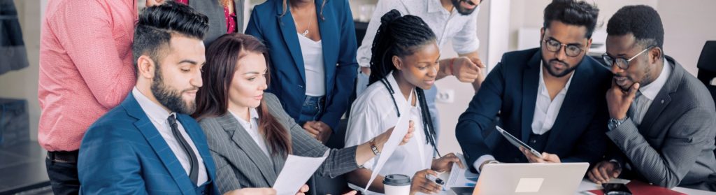 Une groupe de personnes de Schoolab assis en réunion collaborent et échangent des idées ensemble