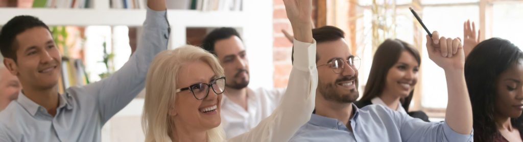 6 personnes de Schoolab sourient et ont la main levées