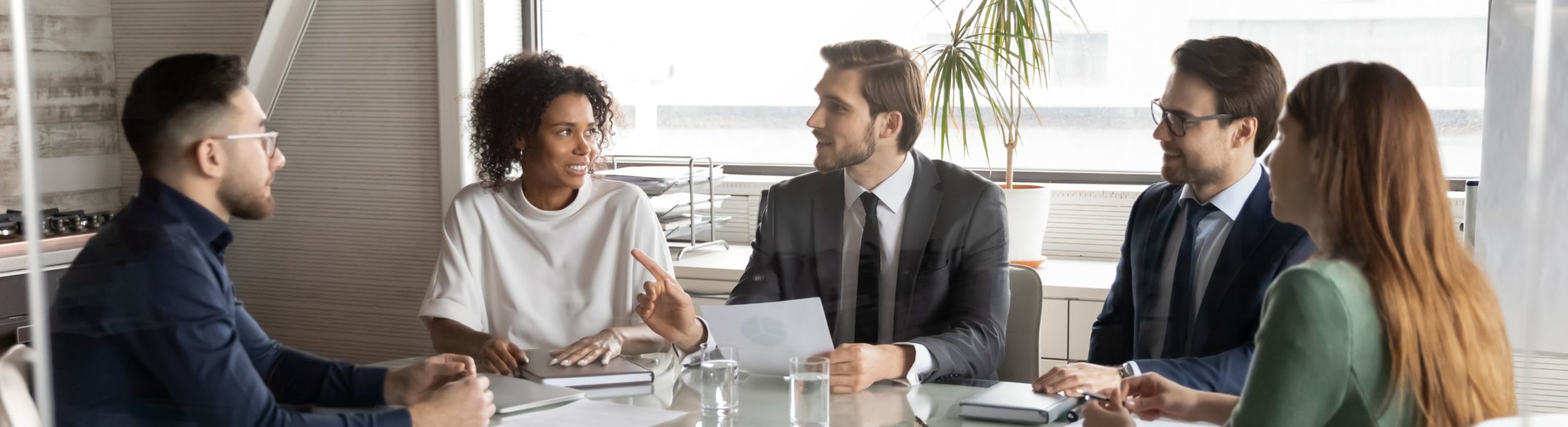 5 membres de Schoolab sont assis autour d'une table pour une réunion