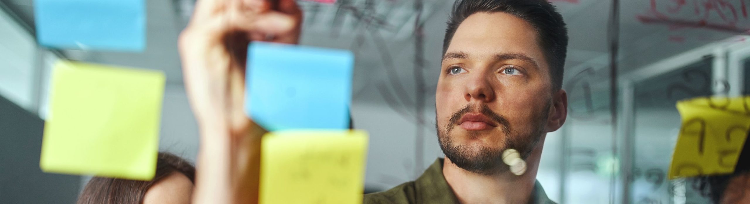 un membre de l'équipe Schoolab utilise une méthode agile avec des postits