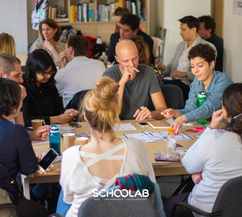 Un groupe de collaborateurs Schoolab participant à un évènement autour d'une table.